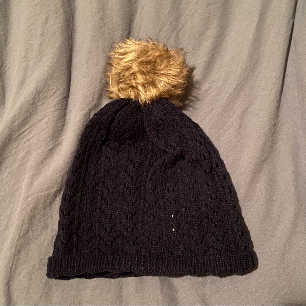 Navy blue knit hat with brown pom pom